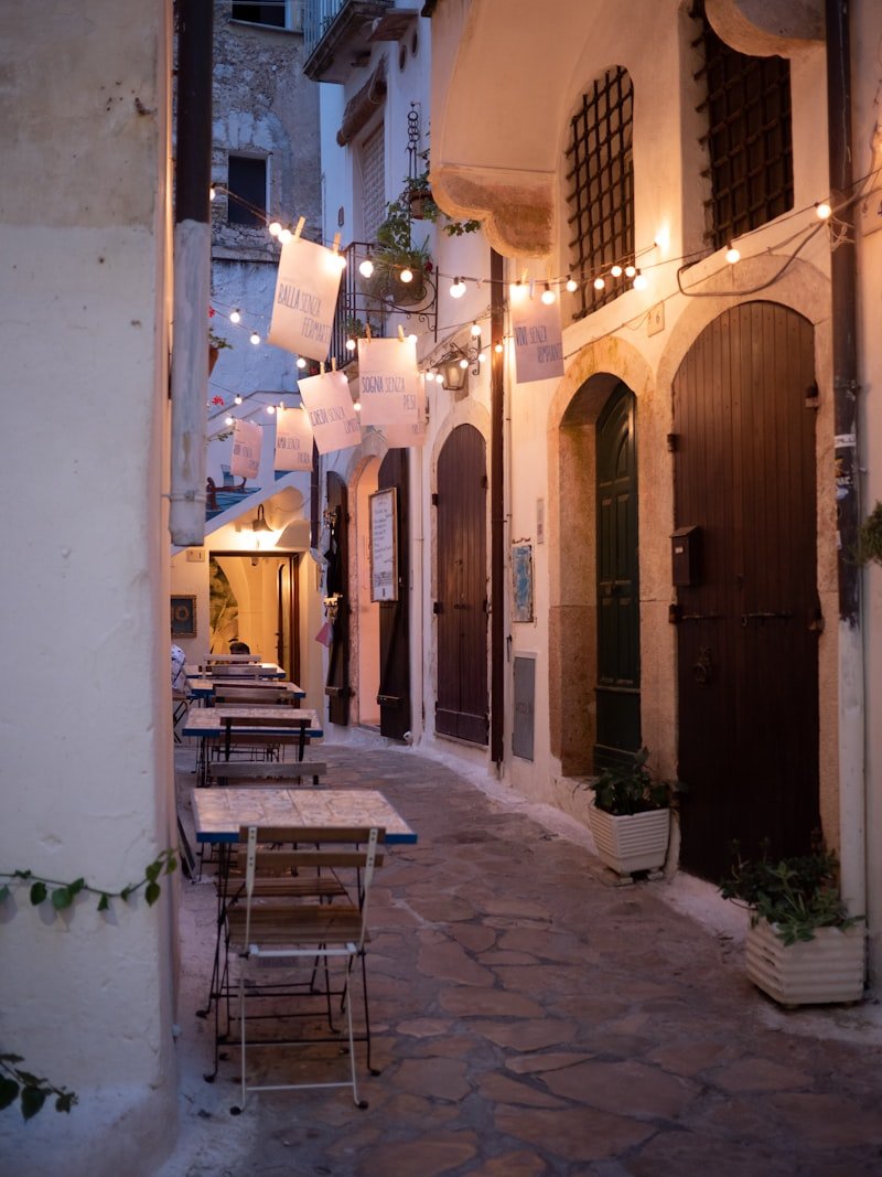 Callejón europeo con terraza y luces al anochecer