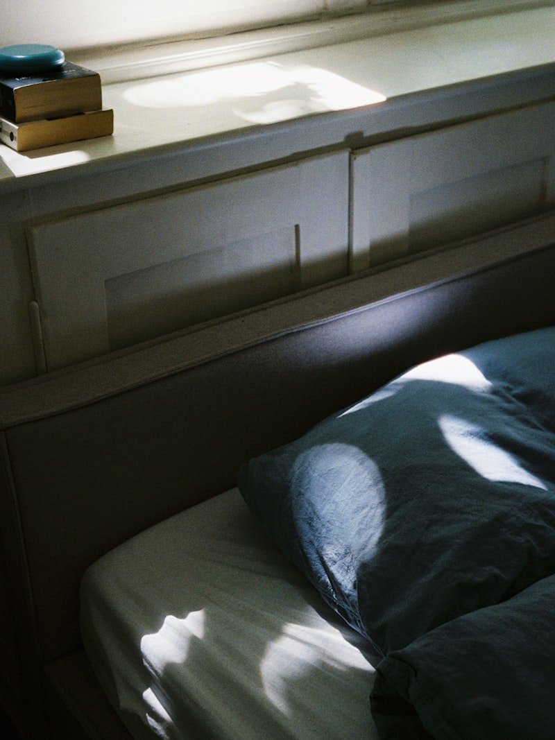 Cama con ropa de lino y luz de mañana entrando por la ventana